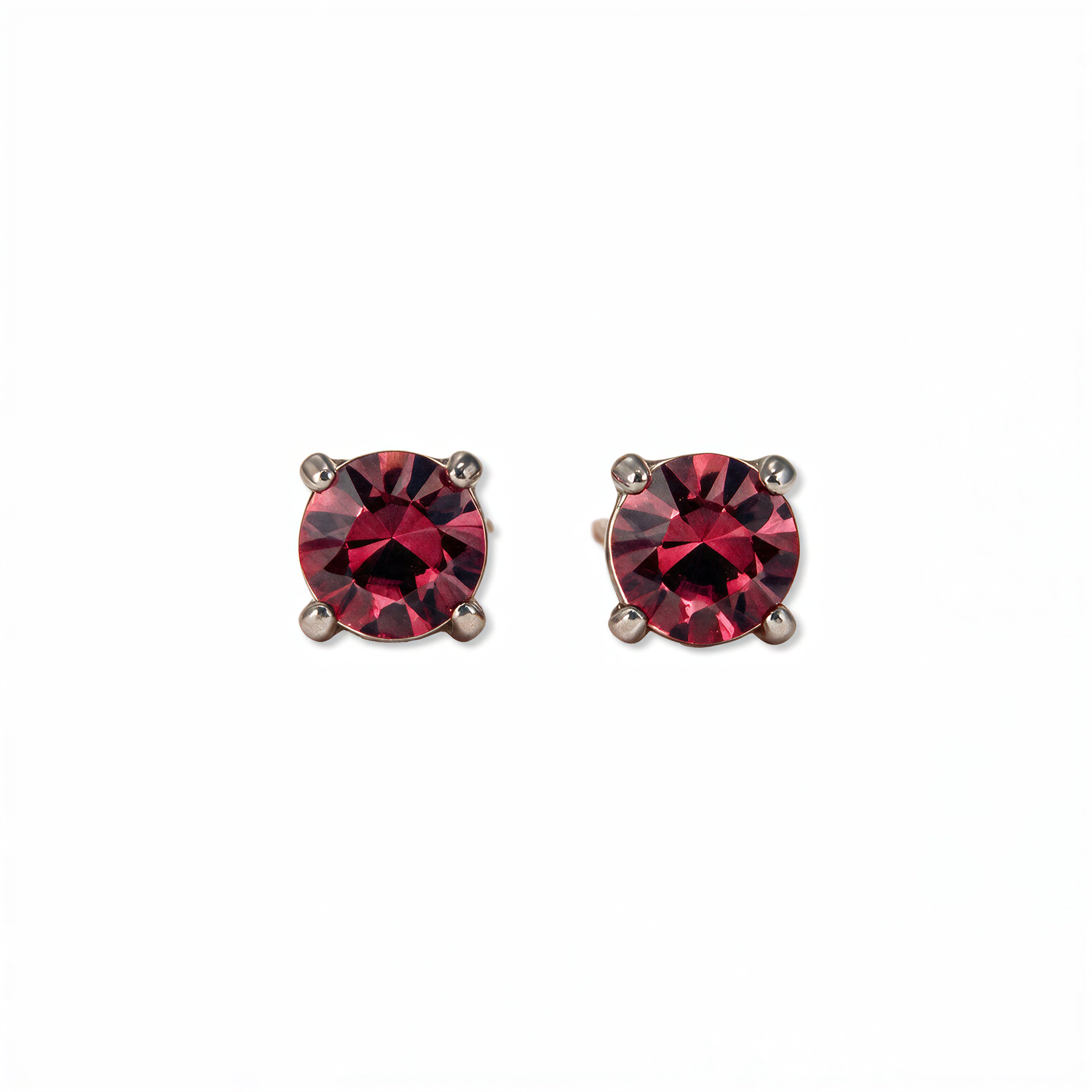 A pair of July Birthstone Round Ruby Cubic Zirconia Stud Earrings by Skōsh Jewelry, featuring faceted red round stones in a four-prong sterling silver setting, displayed against a white background.