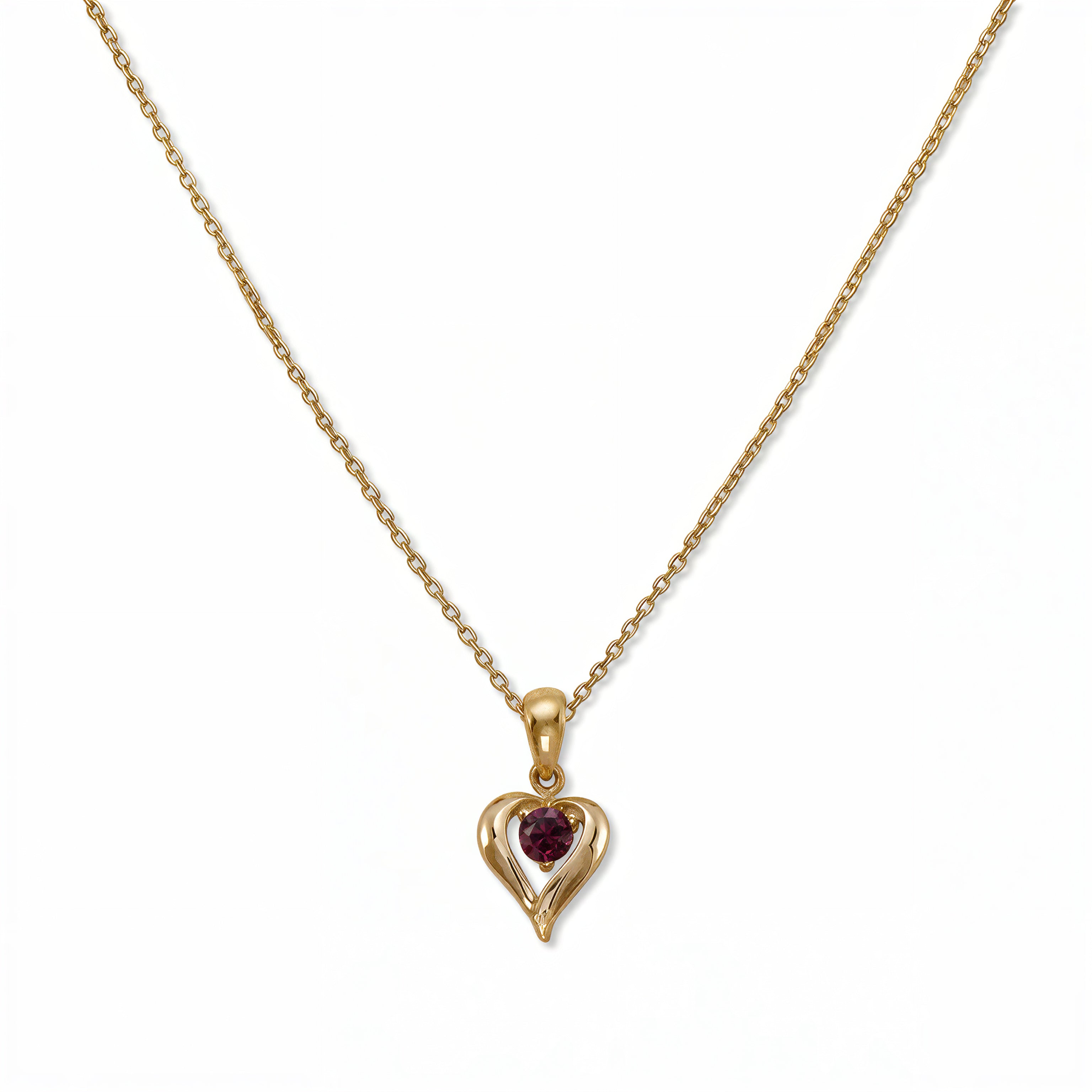 A January Birthstone Garnet Cubic Zirconia Heart Necklace by Skōsh Jewelry, featuring a heart-shaped deep red stone framed in a sculpted gold heart pendant on a fine chain, displayed against a white background.