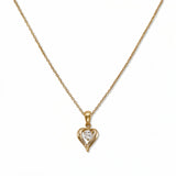 An April Birthstone White Cubic Zirconia Heart Necklace by Skōsh Jewelry, featuring a heart-shaped clear stone framed in a sculpted gold heart pendant on a fine chain, displayed against a white background.