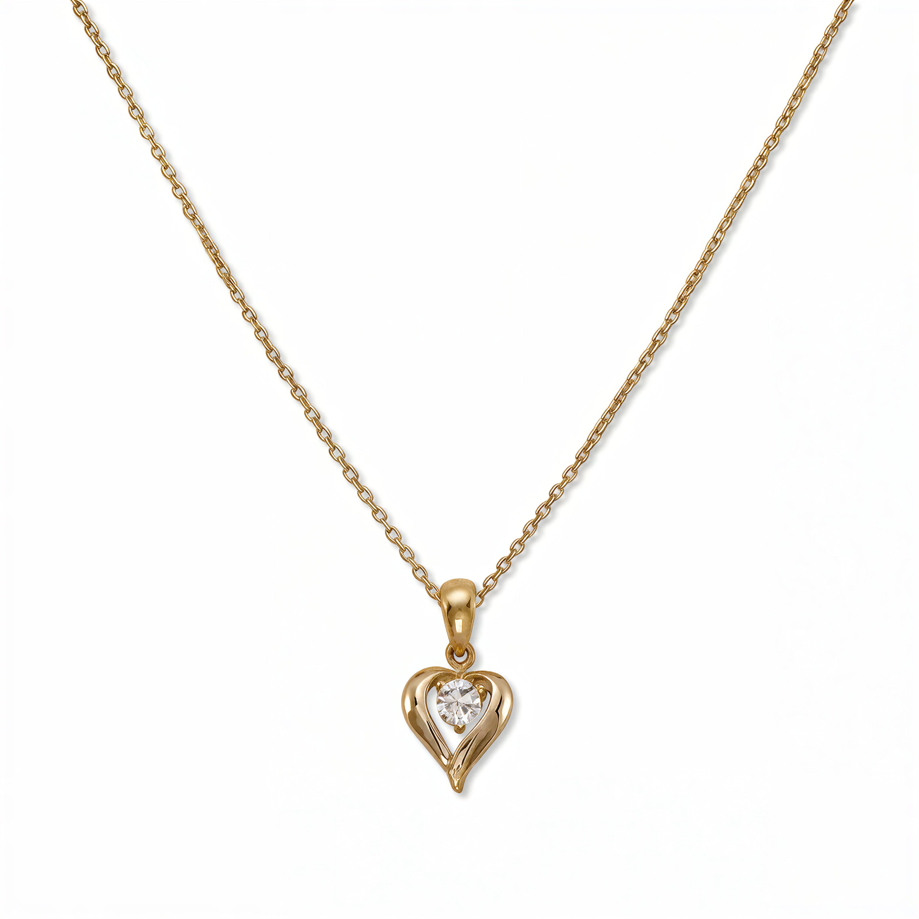 An April Birthstone White Cubic Zirconia Heart Necklace by Skōsh Jewelry, featuring a heart-shaped clear stone framed in a sculpted gold heart pendant on a fine chain, displayed against a white background.