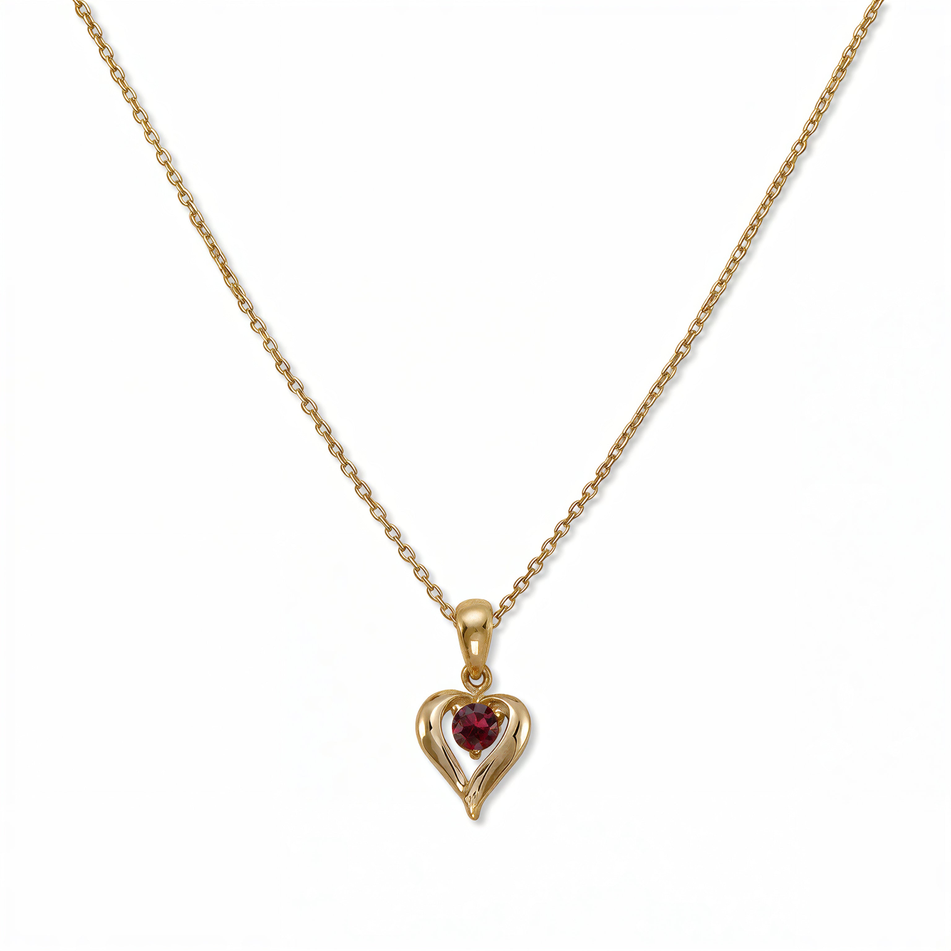 A July Birthstone Ruby Cubic Zirconia Heart Necklace by Skōsh Jewelry, featuring a heart-shaped red stone framed in a sculpted gold heart pendant on a fine chain, displayed against a white background.