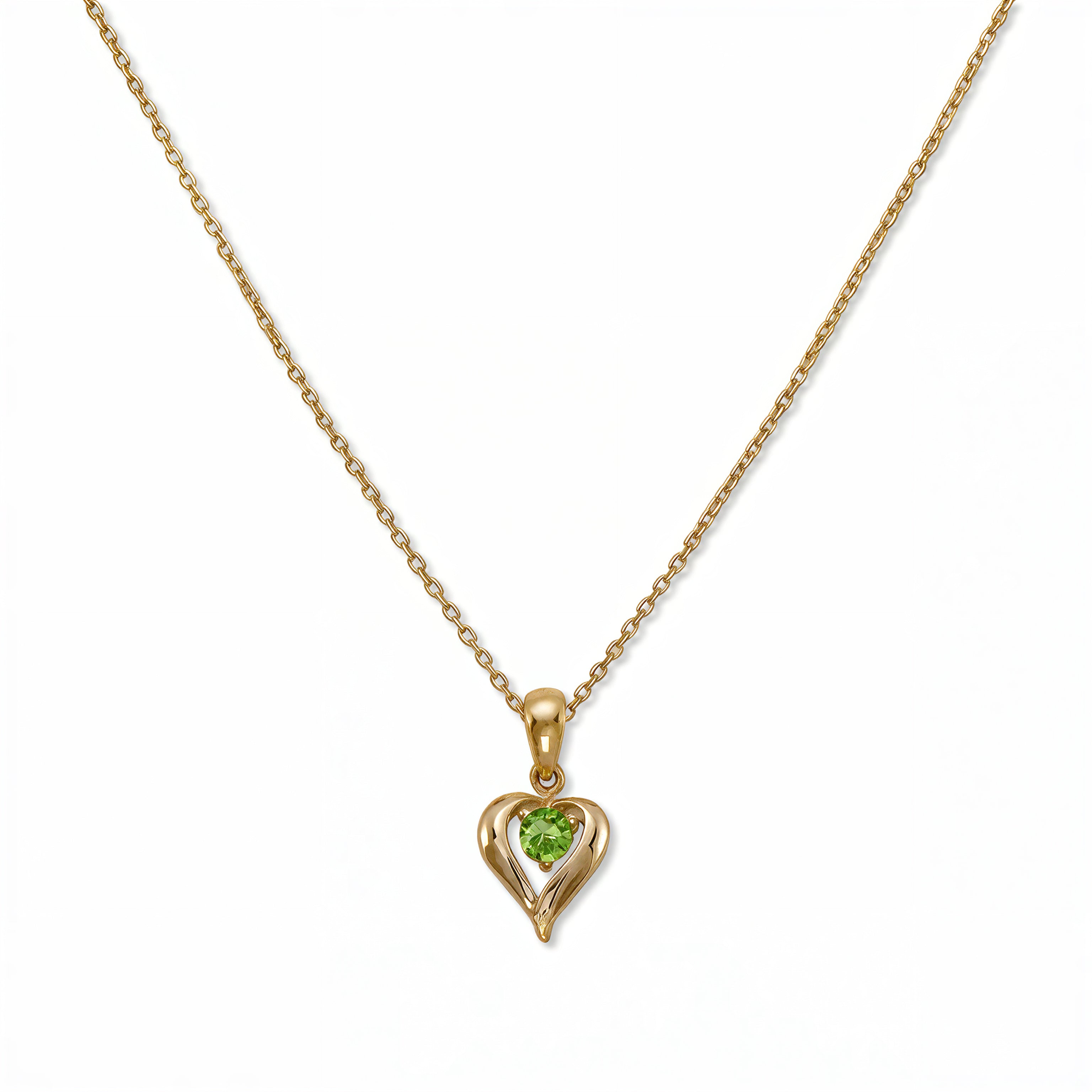 An August Birthstone Peridot Cubic Zirconia Heart Necklace by Skōsh Jewelry, featuring a heart-shaped light green stone framed in a sculpted gold heart pendant on a fine chain, displayed against a white background.