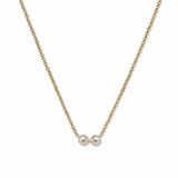 A Skōsh Kids "I'm Two" Petite Freshwater Pearl Necklace by Skōsh Jewelry, featuring two small white freshwater pearls along a fine gold chain, displayed against a white background.