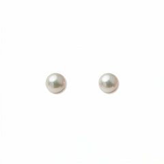 A pair of Freshwater Cultured Pearl 4mm Stud Earrings by Skōsh Jewelry, featuring round, lustrous white freshwater pearls on sterling silver post backs, displayed against a white background.