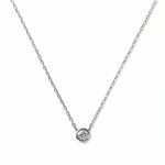 A Stillness Bezel Set White Cubic Zirconia Necklace by Skōsh Jewelry, featuring a single round clear stone in a smooth bezel setting on a fine sterling silver chain, displayed against a white background.