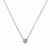 A Stillness Bezel Set White Cubic Zirconia Necklace by Skōsh Jewelry, featuring a single round clear stone in a smooth bezel setting on a fine sterling silver chain, displayed against a white background.