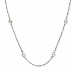 A Nine Station Freshwater Pearl Necklace by Skōsh Jewelry, featuring small white freshwater pearls spaced evenly along a fine sterling silver station chain, displayed against a white background.