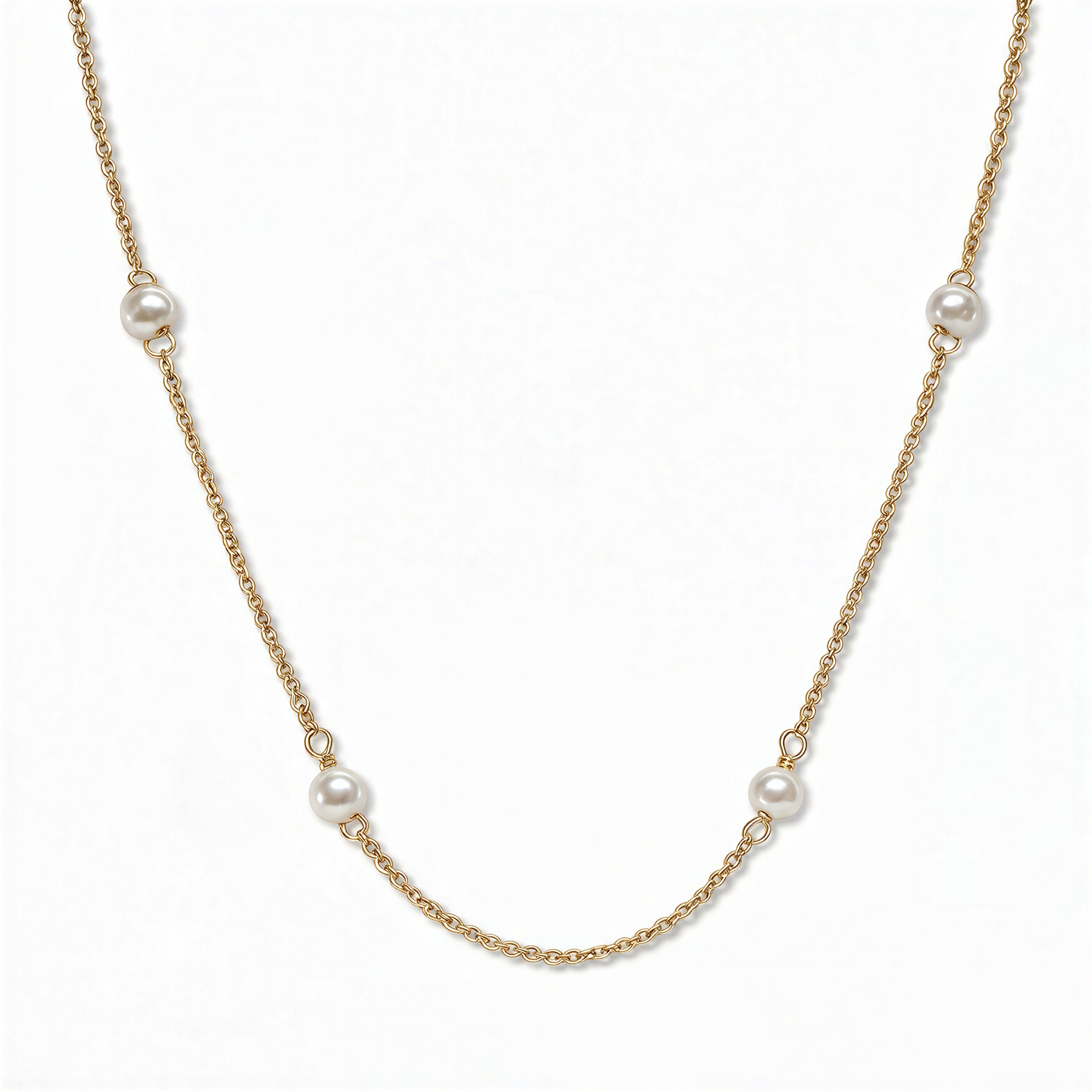 A Nine Station Freshwater Pearl Necklace by Skōsh Jewelry, featuring small white freshwater pearls spaced evenly along a fine gold station chain, displayed against a white background.