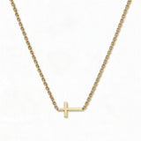 A True Path Inline Sideways Cross Necklace by Skōsh Jewelry, featuring a slim polished cross set sideways on a fine gold chain, displayed against a white background.