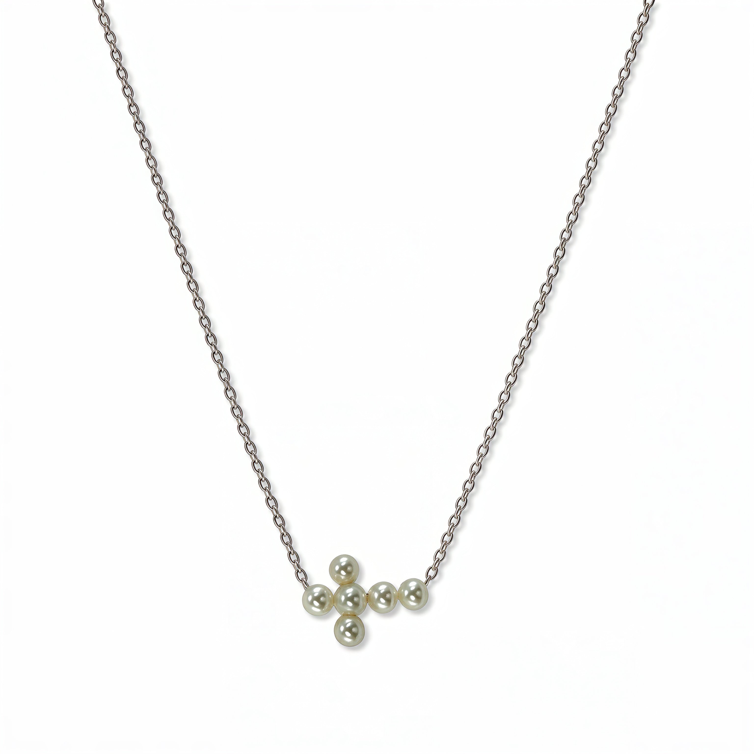 An Eternity Freshwater Pearl Sideways Cross Necklace by Skōsh Jewelry, featuring a sideways cross accented with small white pearls on a fine sterling silver chain, displayed against a white background.