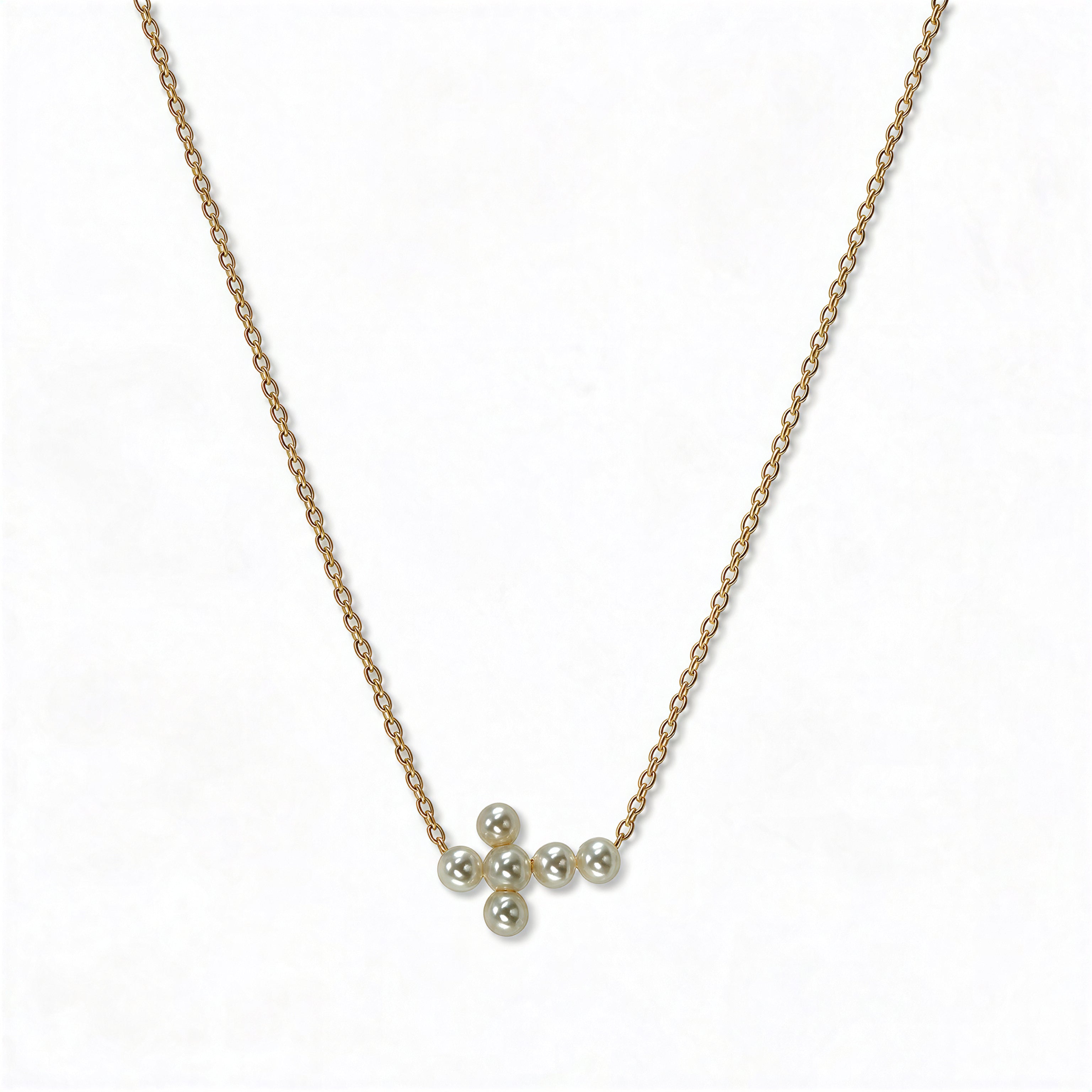 An Eternity Freshwater Pearl Sideways Cross Necklace by Skōsh Jewelry, featuring a sideways cross accented with small white pearls on a fine gold chain, displayed against a white background.