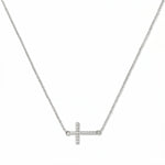 A Devoted White Cubic Zirconia Sideways Cross Necklace by Skōsh Jewelry, featuring a sideways cross lined with small clear pavé stones on a fine sterling silver chain, displayed against a white background.