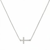 A Devoted White Cubic Zirconia Sideways Cross Necklace by Skōsh Jewelry, featuring a sideways cross lined with small clear pavé stones on a fine sterling silver chain, displayed against a white background.