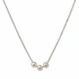 A Timeless Trio Freshwater Pearl Necklace by Skōsh Jewelry, featuring three white freshwater pearls in a row along a fine sterling silver chain, displayed against a white background.