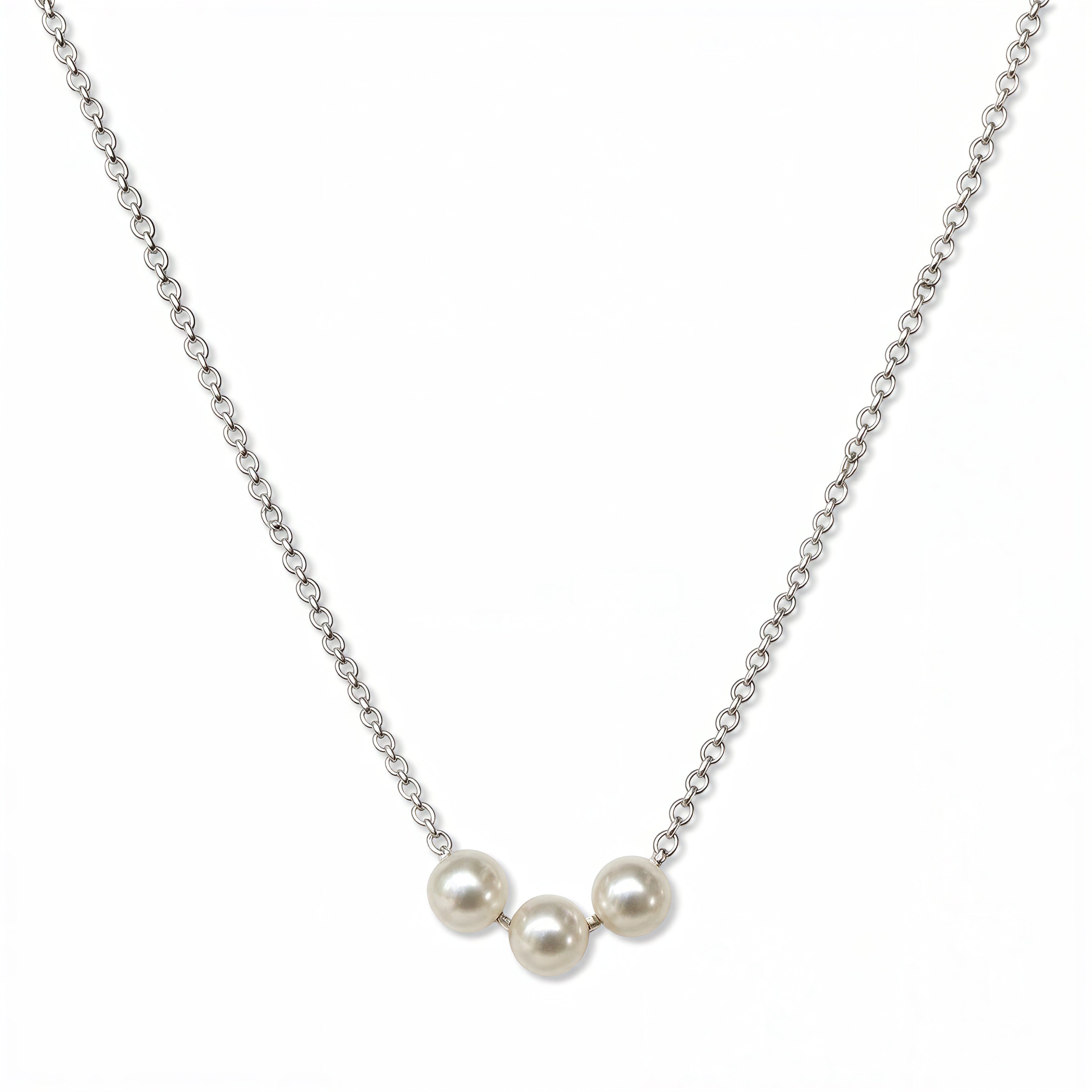 A Timeless Trio Freshwater Pearl Necklace by Skōsh Jewelry, featuring three white freshwater pearls in a row along a fine sterling silver chain, displayed against a white background.