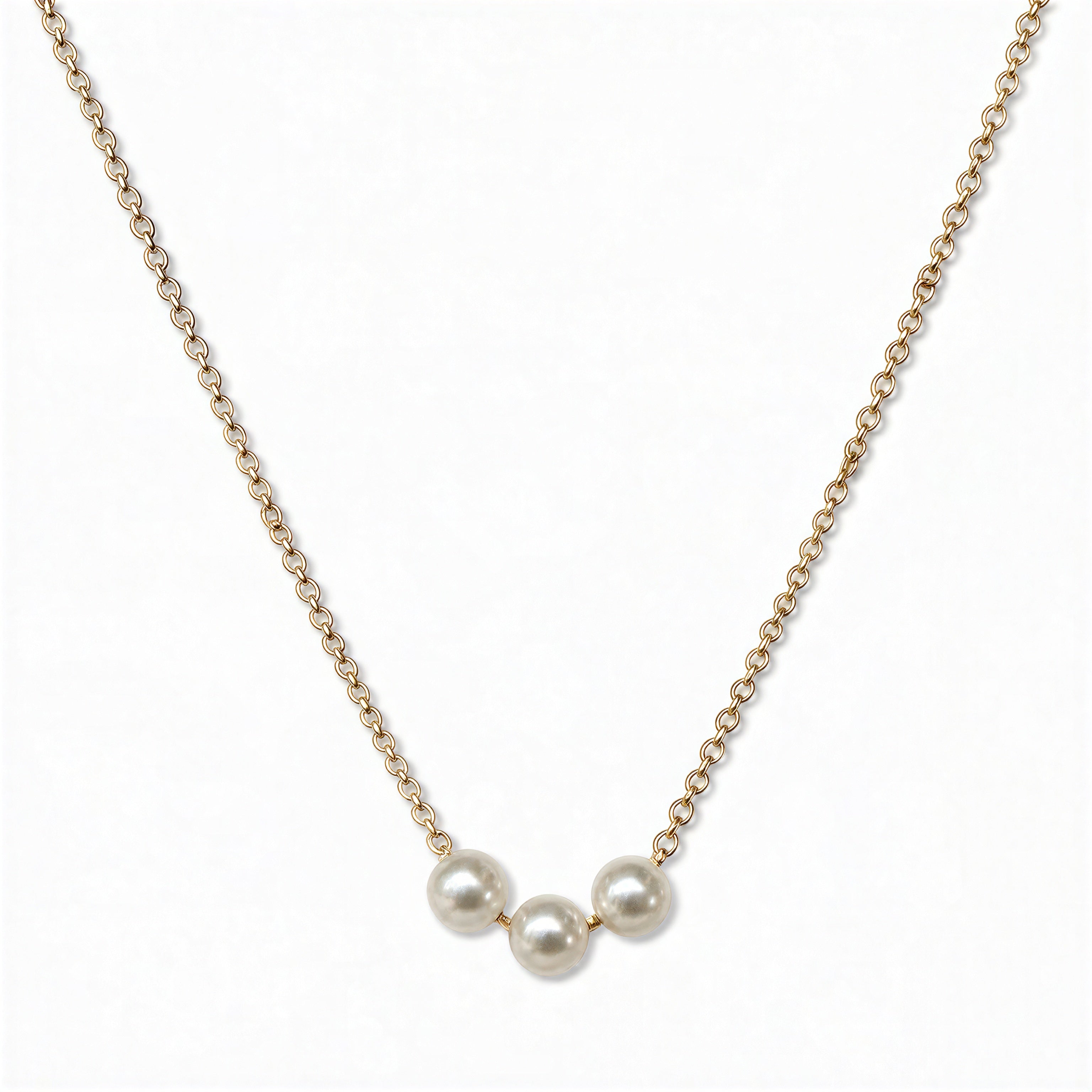 A Timeless Trio Freshwater Pearl Necklace by Skōsh Jewelry, featuring three white freshwater pearls in a row along a fine gold chain, displayed against a white background.