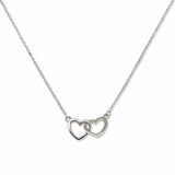 A Forever Love Interlocking Hearts Necklace by Skōsh Jewelry, featuring two open hearts linked together on a fine sterling silver chain, displayed against a white background.