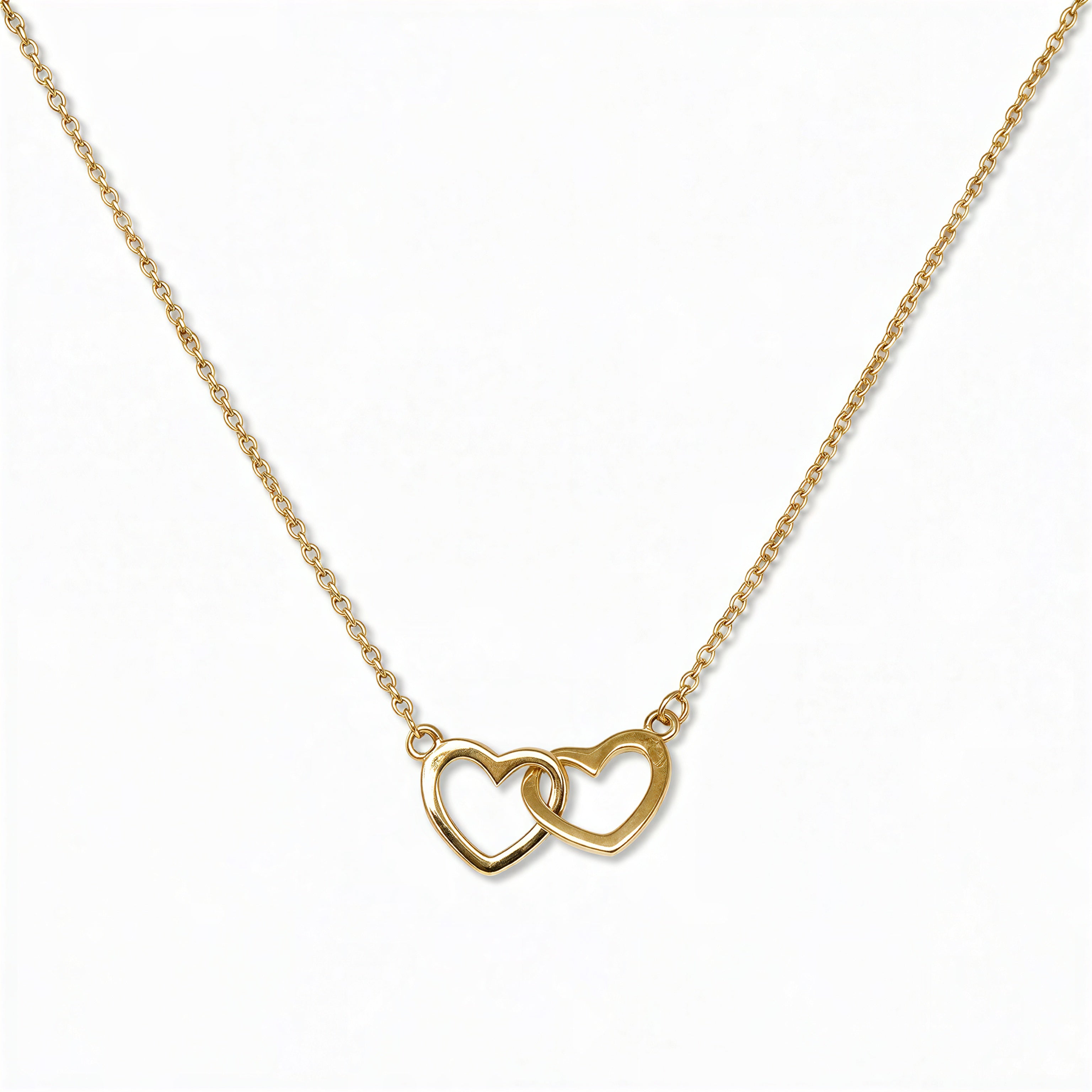 A Forever Love Interlocking Hearts Necklace by Skōsh Jewelry, featuring two open hearts linked together on a fine gold chain, displayed against a white background.