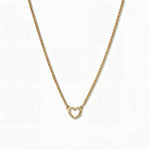 A Lucent Mini Heart Necklace by Skōsh Jewelry, featuring a tiny open heart set on a fine gold chain, displayed against a white background.