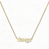 A Dawgs Gameday Necklace by Skōsh Jewelry, featuring the word 'dawgs' in lowercase letters set horizontally on a fine gold chain, displayed against a white background.