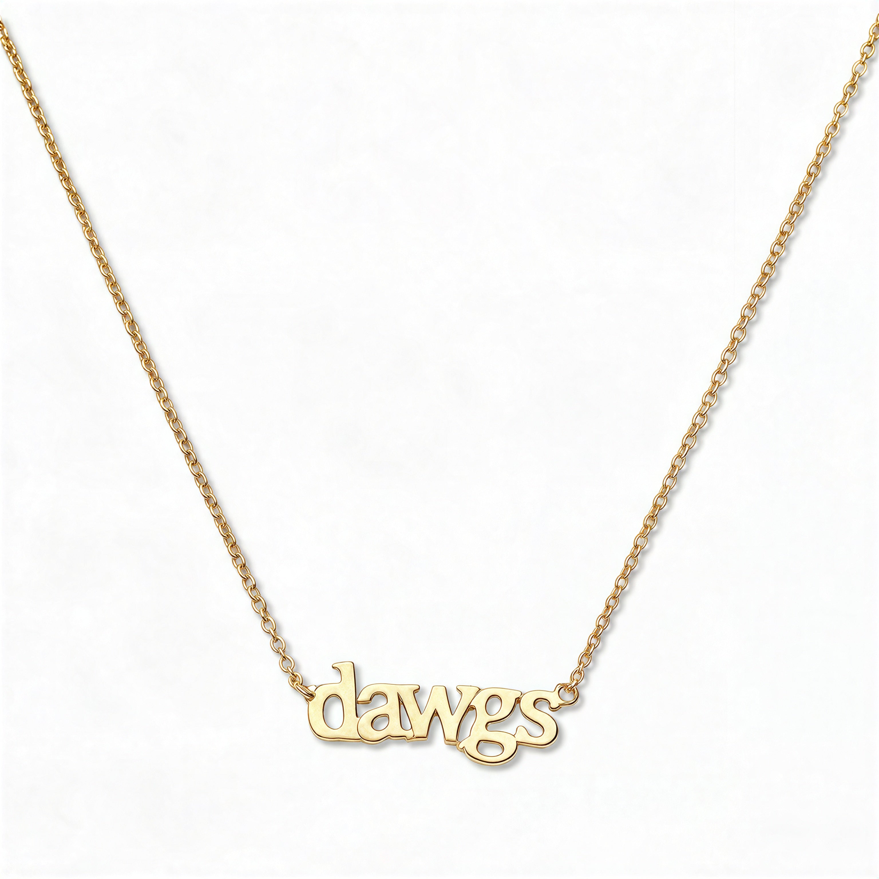 A Dawgs Gameday Necklace by Skōsh Jewelry, featuring the word 'dawgs' in lowercase letters set horizontally on a fine gold chain, displayed against a white background.