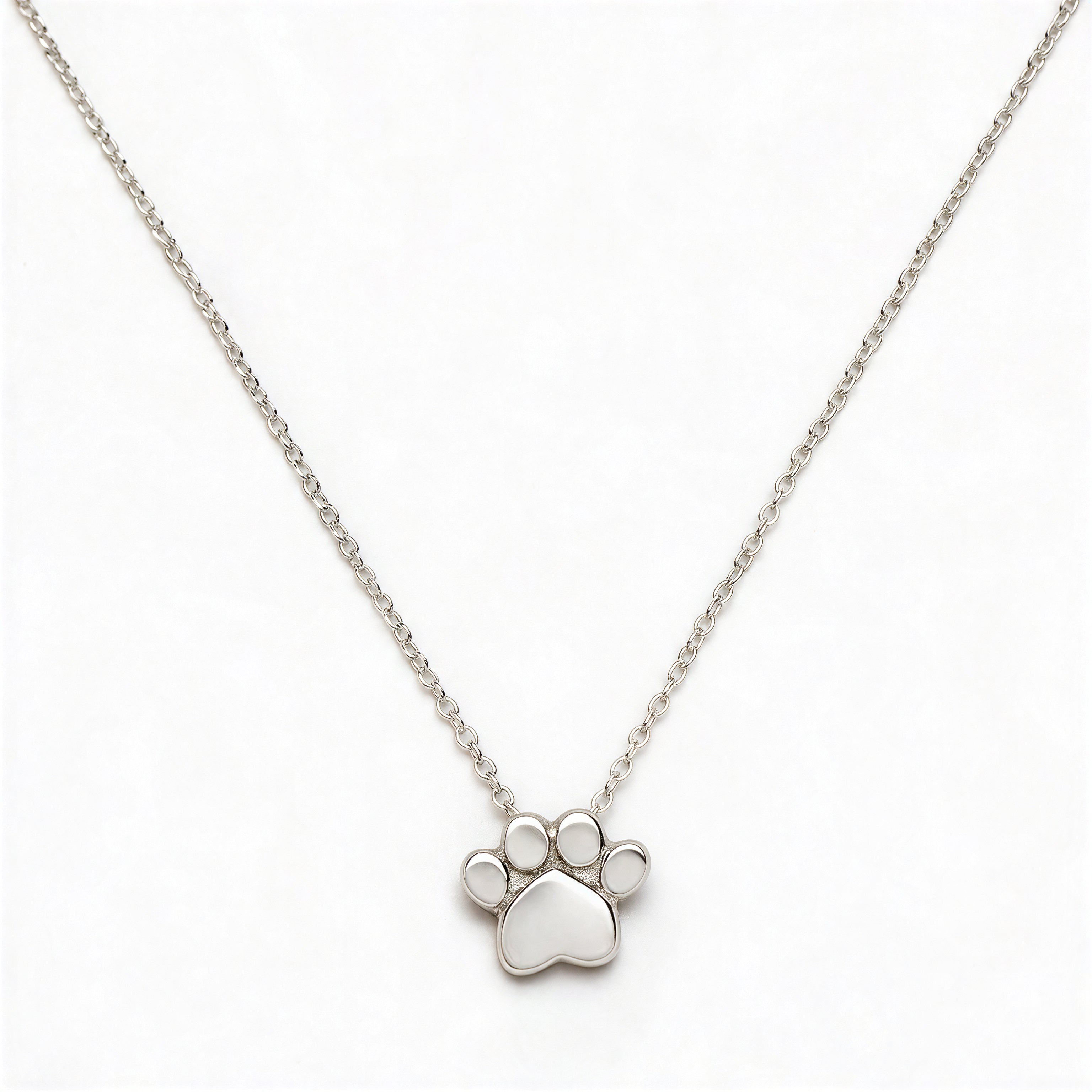 A Bulldogs Paw Print Gameday Necklace by Skōsh Jewelry, featuring a polished paw print pendant on a fine sterling silver chain, displayed against a white background.