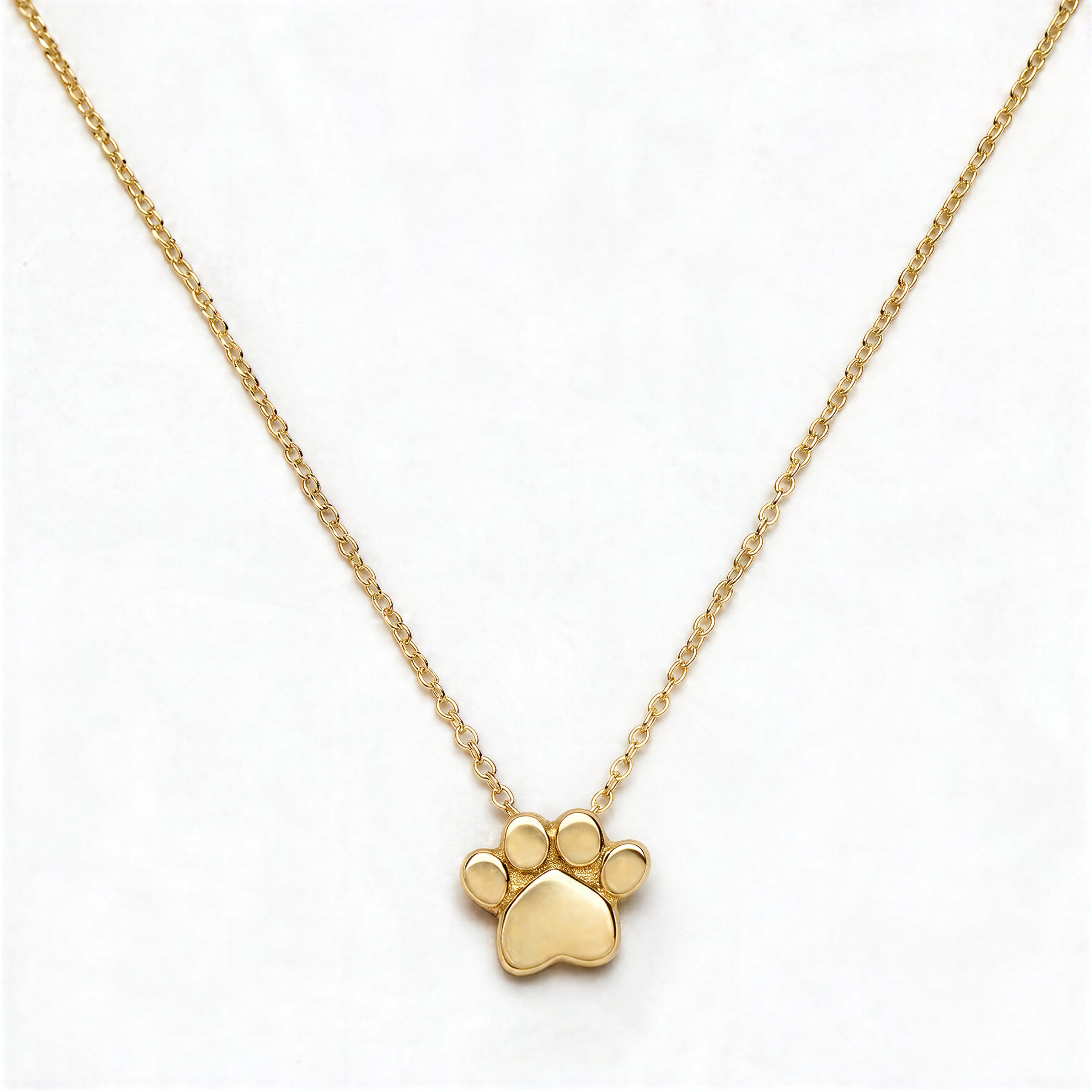 A Bulldogs Paw Print Gameday Necklace by Skōsh Jewelry, featuring a polished paw print pendant on a fine gold chain, displayed against a white background.