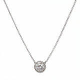 An Elysian Glow Round White Cubic Zirconia Halo Necklace by Skōsh Jewelry, featuring a large round clear stone surrounded by a halo of smaller stones on a fine sterling silver chain, displayed against a white background.