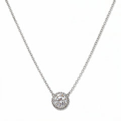 An Elysian Glow Round White Cubic Zirconia Halo Necklace by Skōsh Jewelry, featuring a large round clear stone surrounded by a halo of smaller stones on a fine sterling silver chain, displayed against a white background.