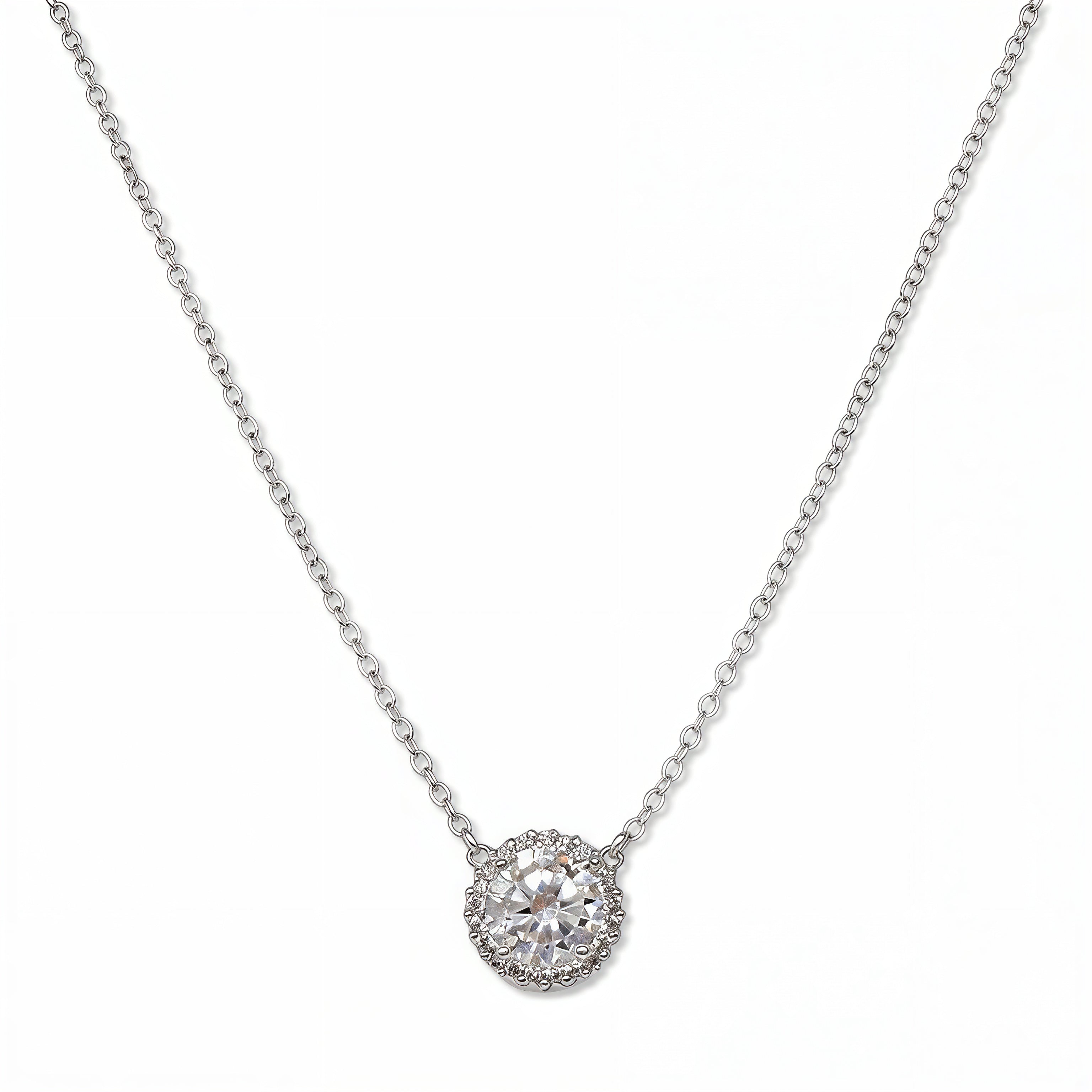 An Elysian Glow Round White Cubic Zirconia Halo Necklace by Skōsh Jewelry, featuring a large round clear stone surrounded by a halo of smaller stones on a fine sterling silver chain, displayed against a white background.