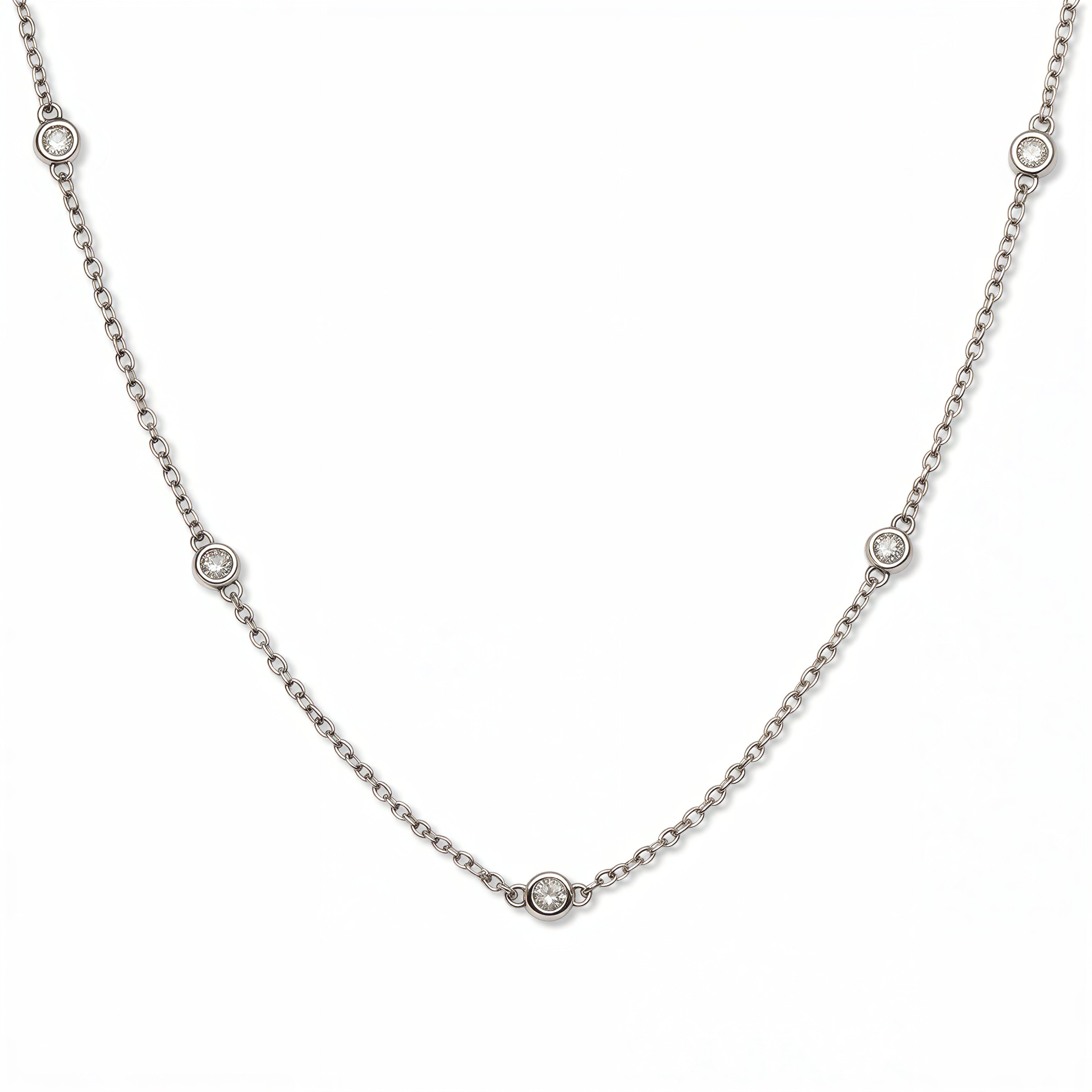 A Starlight Strand Bezel Station White Cubic Zirconia Necklace by Skōsh Jewelry, featuring small round clear stones in bezel settings spaced along a fine sterling silver chain, displayed against a white background.