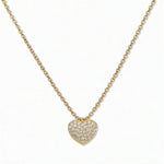 An Affection Pavé Heart White Cubic Zirconia Necklace by Skōsh Jewelry, featuring a puffed heart covered in small clear pavé stones on a fine gold chain, displayed against a white background.