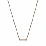 A Luminous White Cubic Zirconia Short Bar Necklace by Skōsh Jewelry, featuring a short slim bar lined with small clear stones on a fine sterling silver chain, displayed against a white background.