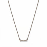 A Luminous White Cubic Zirconia Short Bar Necklace by Skōsh Jewelry, featuring a short slim bar lined with small clear stones on a fine sterling silver chain, displayed against a white background.