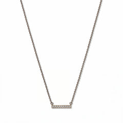 A Luminous White Cubic Zirconia Short Bar Necklace by Skōsh Jewelry, featuring a short slim bar lined with small clear stones on a fine sterling silver chain, displayed against a white background.