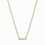 A Luminous White Cubic Zirconia Short Bar Necklace by Skōsh Jewelry, featuring a short slim bar lined with small clear stones on a fine gold chain, displayed against a white background.