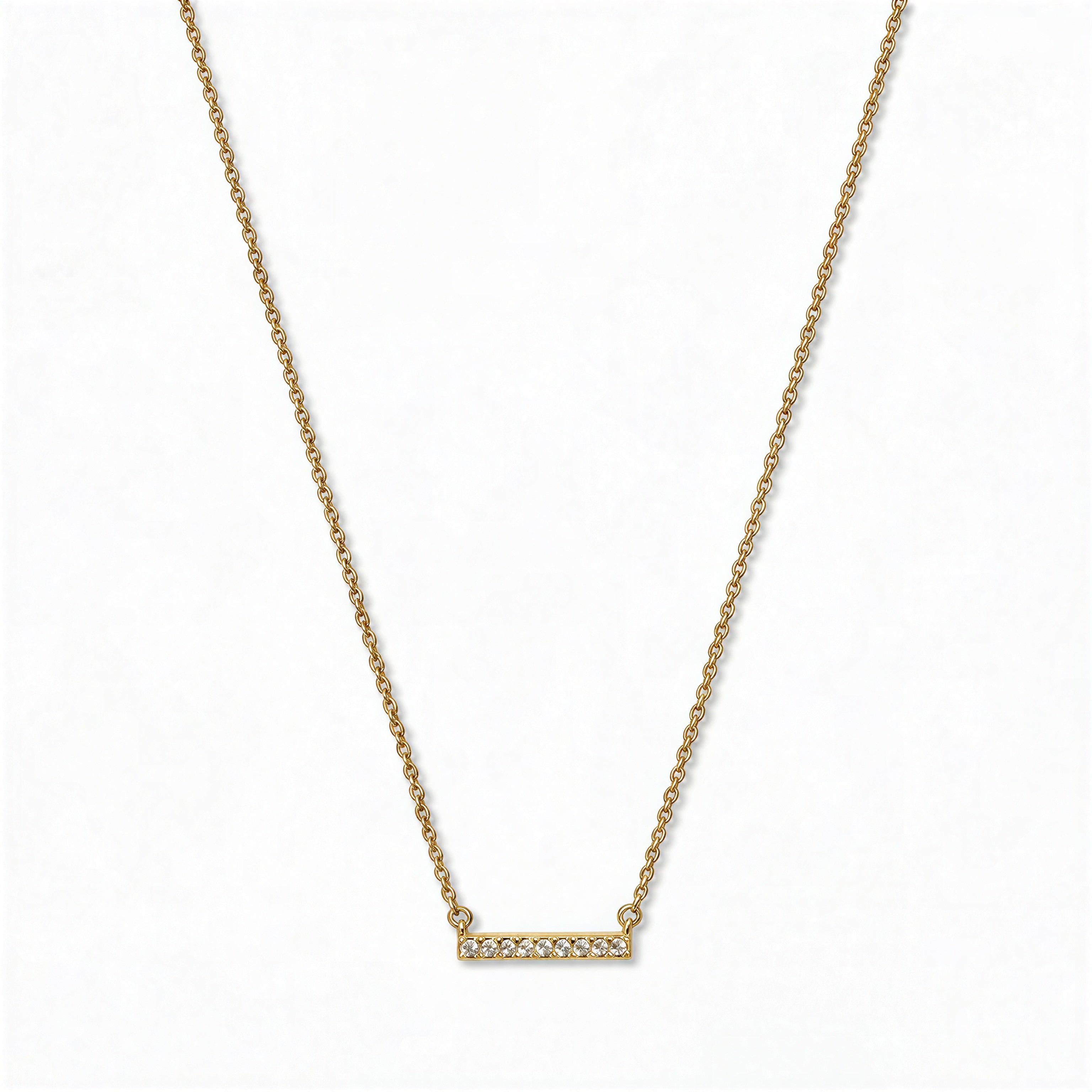 A Luminous White Cubic Zirconia Short Bar Necklace by Skōsh Jewelry, featuring a short slim bar lined with small clear stones on a fine gold chain, displayed against a white background.