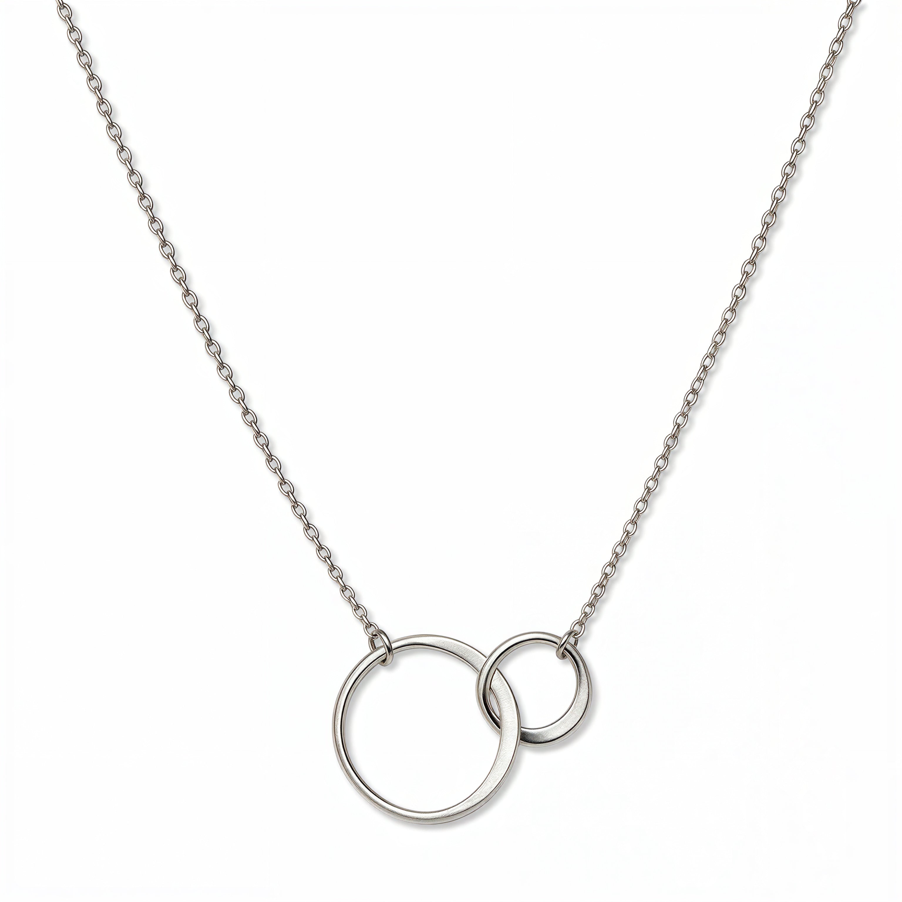 A Held Close Mother and Daughter Circles Necklace by Skōsh Jewelry, featuring one large and one small open circle linked together on a fine sterling silver chain, displayed against a white background.