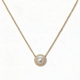 A Freshwater Pearl with White Cubic Zirconia Halo Necklace by Skōsh Jewelry, featuring a round white freshwater pearl surrounded by a halo of small clear stones on a fine gold chain, displayed against a white background.