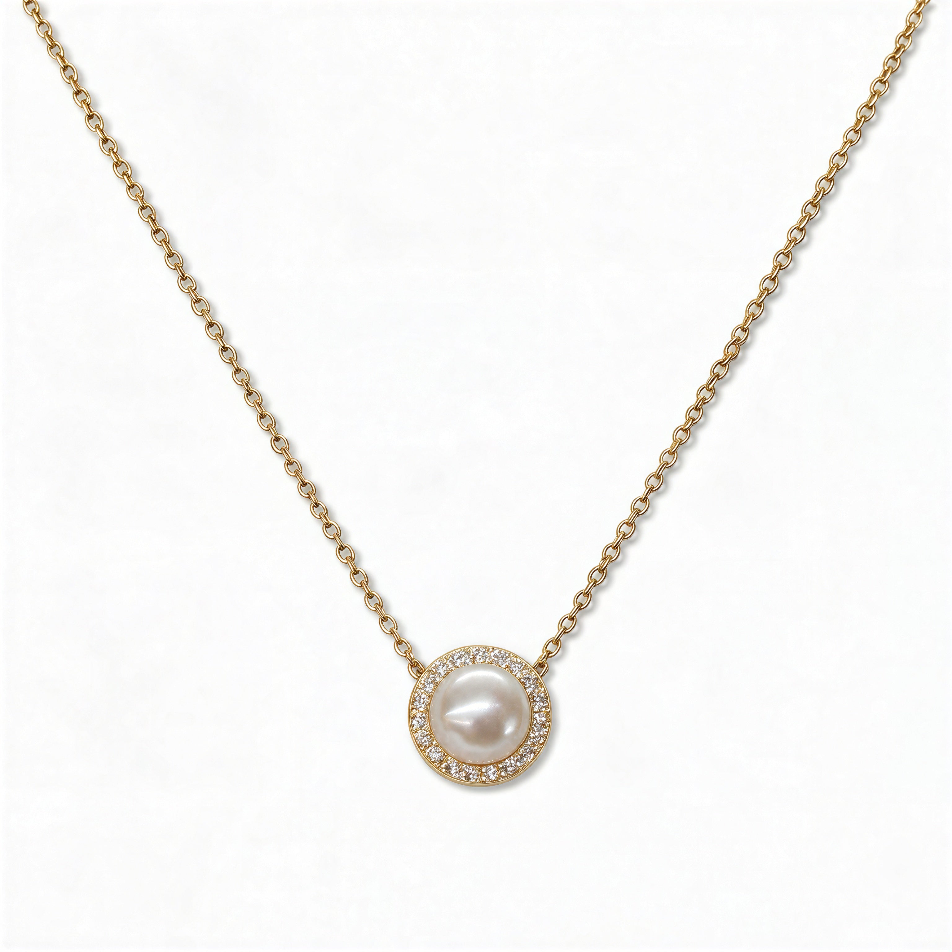 A Freshwater Pearl with White Cubic Zirconia Halo Necklace by Skōsh Jewelry, featuring a round white freshwater pearl surrounded by a halo of small clear stones on a fine gold chain, displayed against a white background.