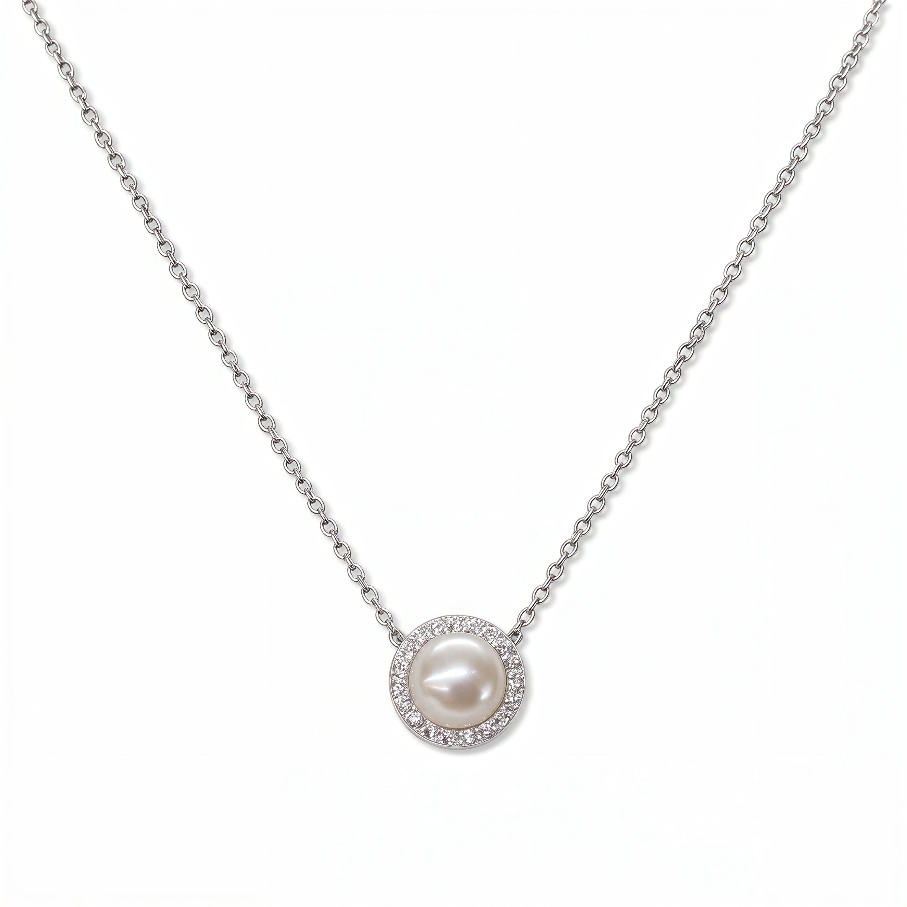 A Freshwater Pearl with White Cubic Zirconia Halo Necklace by Skōsh Jewelry, featuring a round white freshwater pearl surrounded by a halo of small clear stones on a fine sterling silver chain, displayed against a white background.