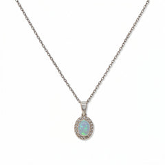 An Ethereal Opal with White Cubic Zirconia Halo Pendant Necklace by Skōsh Jewelry, featuring an oval iridescent opal framed by a halo of small clear stones on a fine sterling silver chain, displayed against a white background.