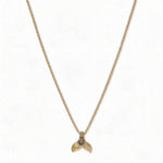 A Mermaid Tail Pendant Necklace by Skōsh Jewelry, featuring a small textured mermaid tail pendant on a fine gold chain, displayed against a white background.