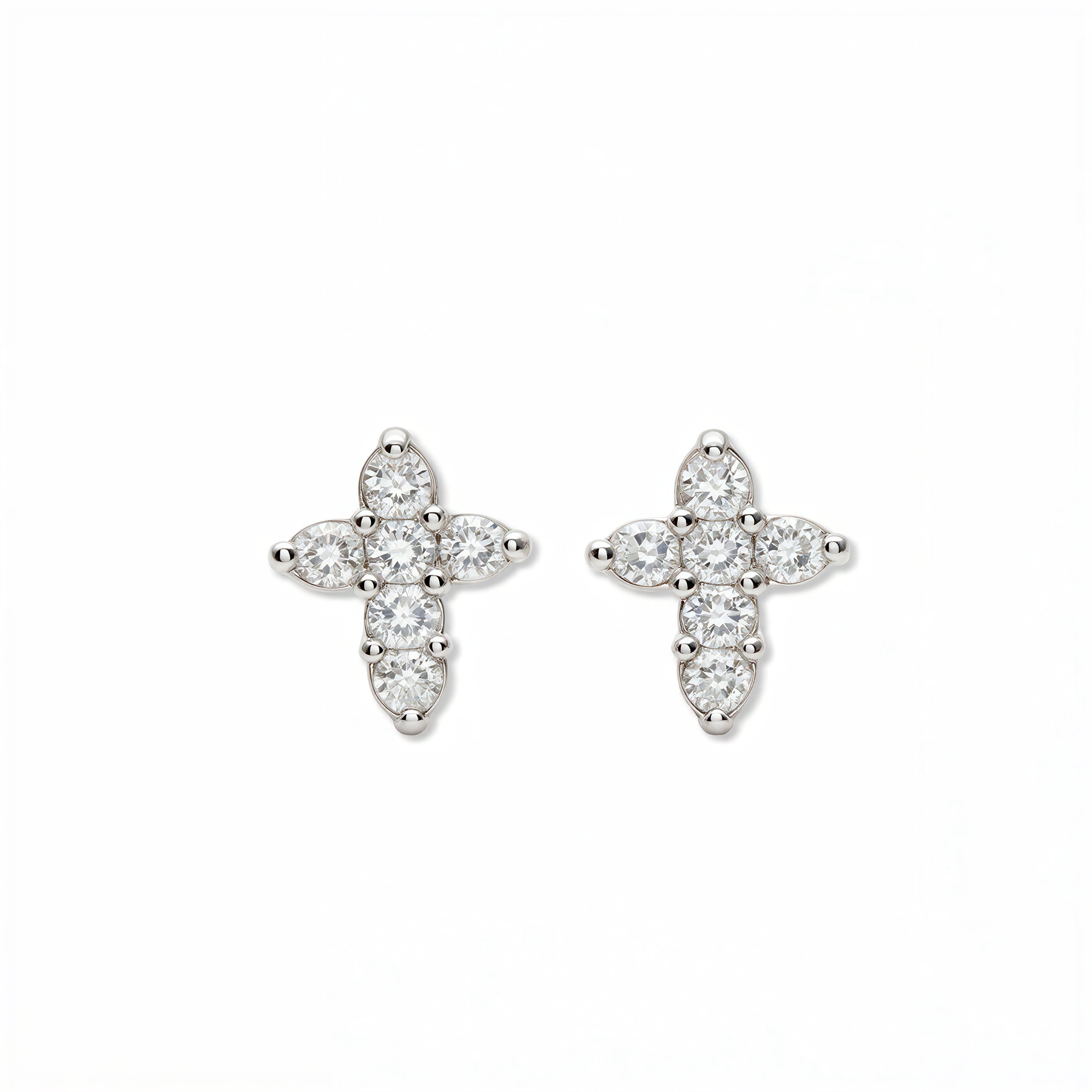A pair of Shine Mini Cross with White Cubic Zirconia Earrings by Skōsh Jewelry, featuring small crosses formed from clear stones in sterling silver, displayed against a white background.