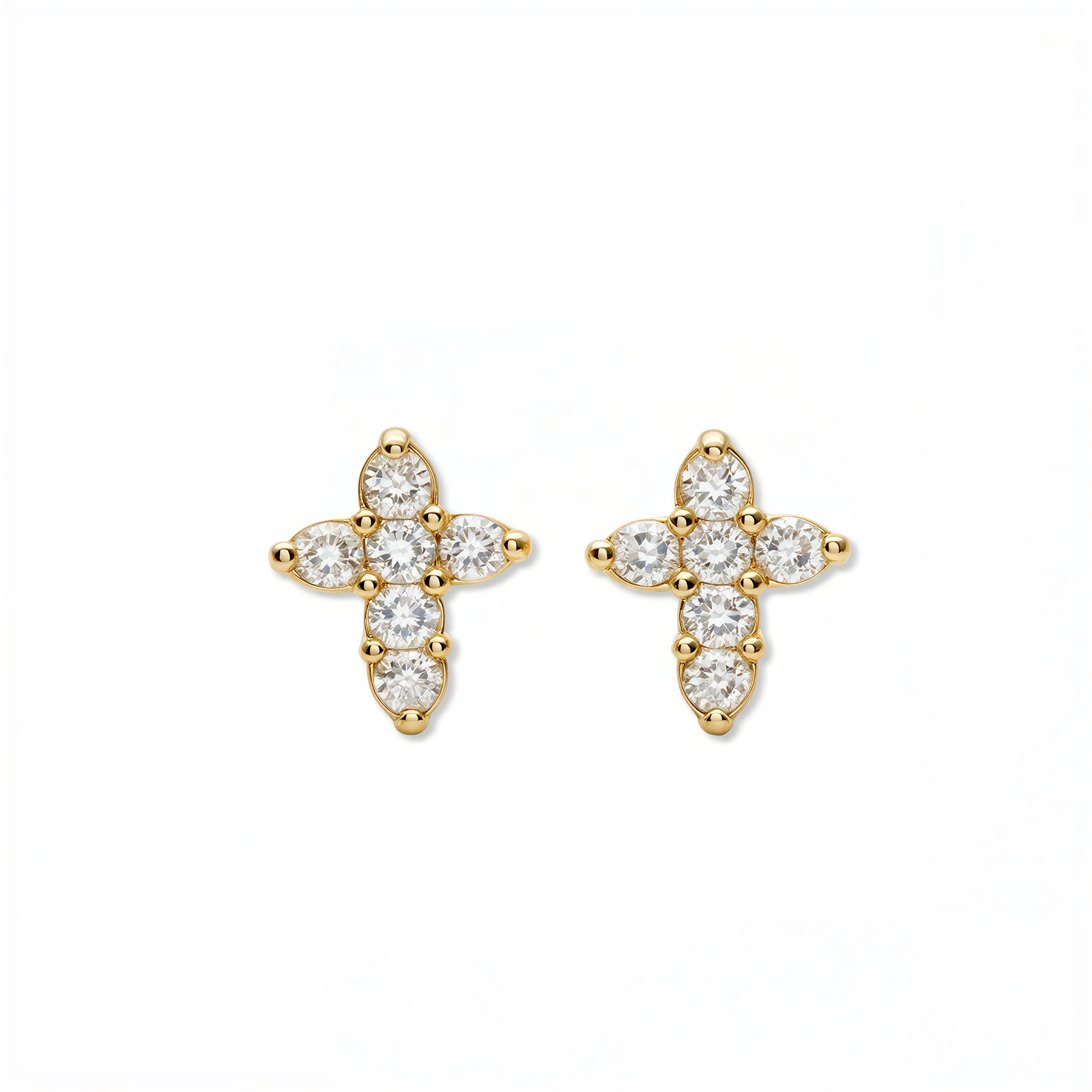A pair of Shine Mini Cross with White Cubic Zirconia Earrings by Skōsh Jewelry, featuring small crosses formed from clear stones in gold, displayed against a white background.
