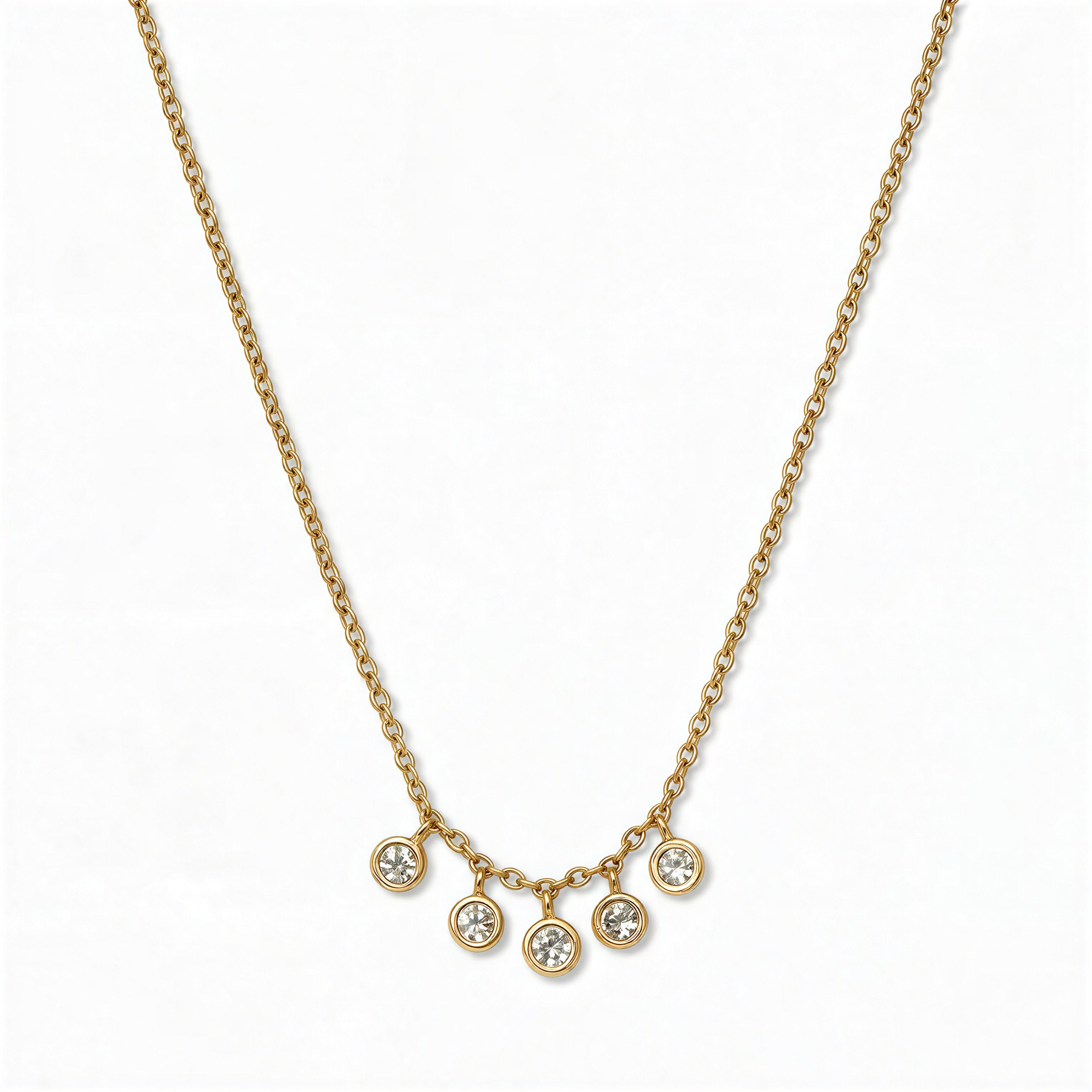 A Twinkle Five Drop White Cubic Zirconia Necklace by Skōsh Jewelry, featuring five small bezel-set clear stones dangling from the center of a fine gold chain, displayed against a white background.