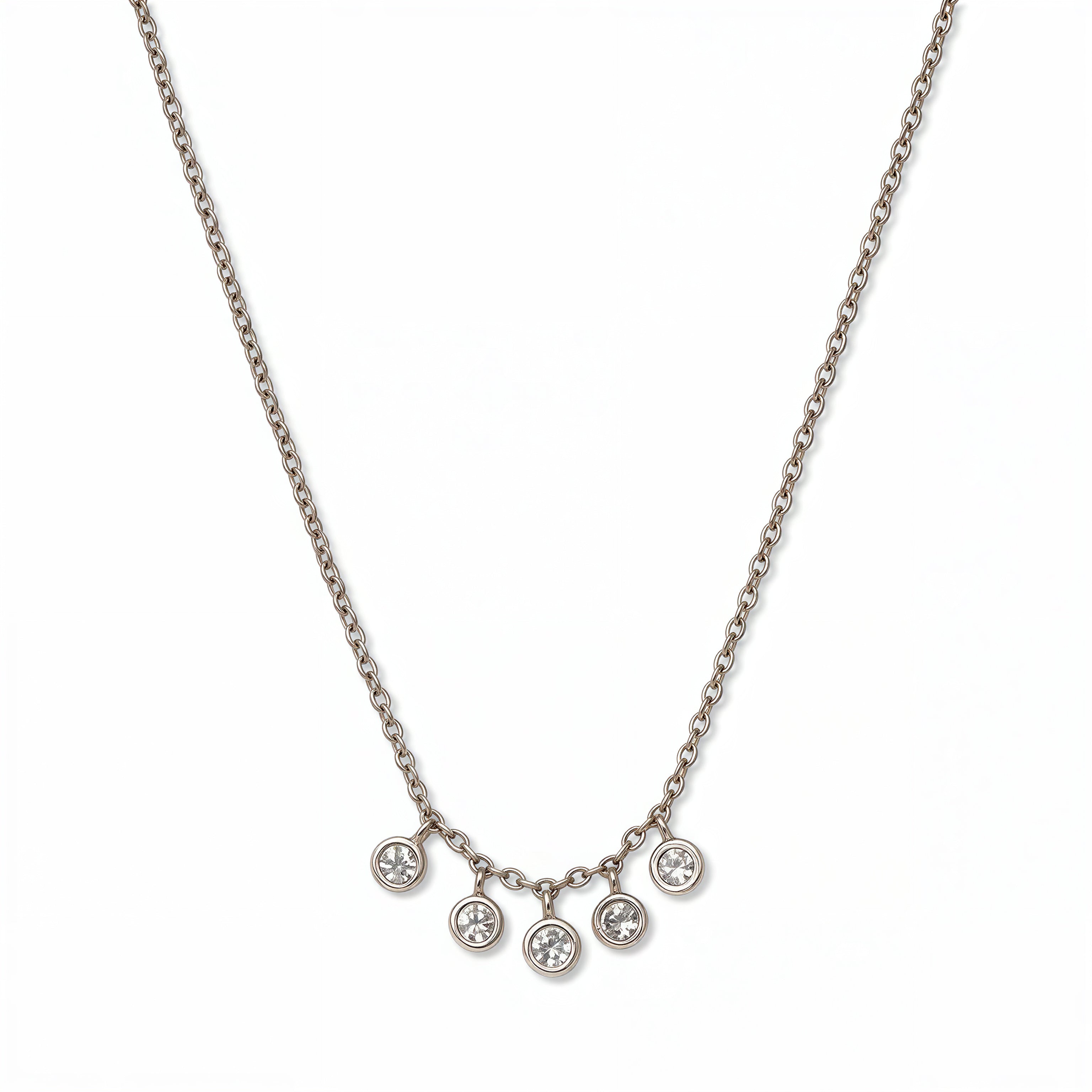 A Twinkle Five Drop White Cubic Zirconia Necklace by Skōsh Jewelry, featuring five small bezel-set clear stones dangling from the center of a fine sterling silver chain, displayed against a white background.