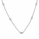 A Sanctuary Bezel Set White Cubic Zirconia Station Necklace by Skōsh Jewelry, featuring five small bezel-set clear stones spaced along a fine sterling silver chain, displayed against a white background.