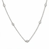 A Sanctuary Bezel Set White Cubic Zirconia Station Necklace by Skōsh Jewelry, featuring five small bezel-set clear stones spaced along a fine sterling silver chain, displayed against a white background.