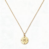 A True North Engraved Compass Pendant Necklace by Skōsh Jewelry, featuring a round compass medallion engraved with a compass rose on a fine gold chain, displayed against a white background.